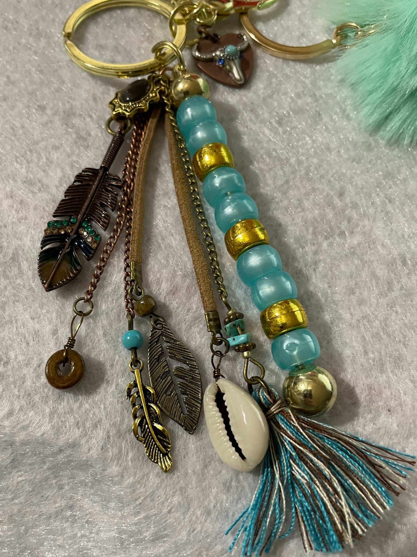 Western keychain close up of feathers and seashell
