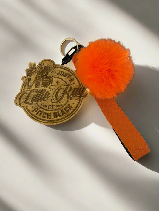 Little Ray of Pitch Black Keychain with orange pom pom and lanyard